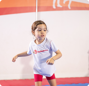 Criança praticando ginástica em sala de atividades