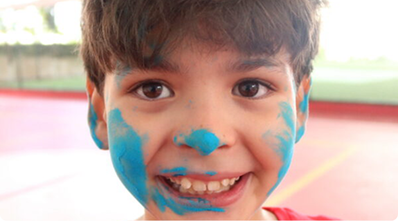 Criança do Colégio Anchieta com o rosto pintado de azul